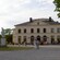 Groups of people standing outside a multi window rococo theater
